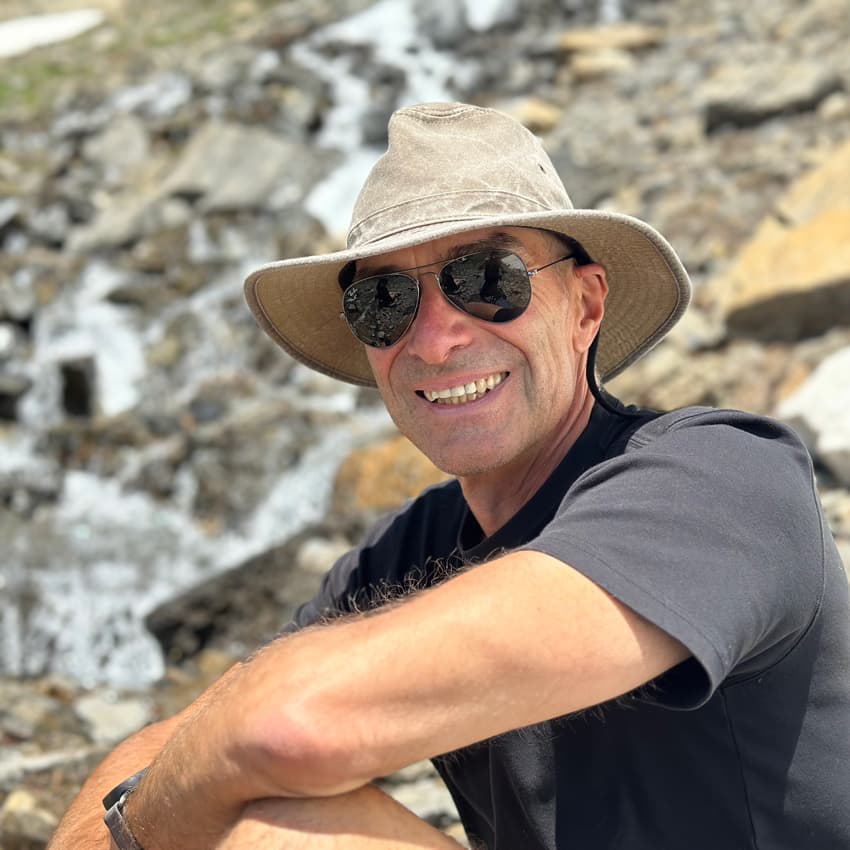 Wellness coach Alfons sitting on a mountain after a hike